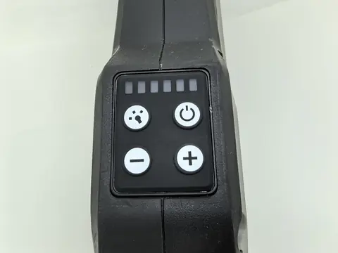 Close-up of a moulded silicone keypad in a black housing: four keys printed with power, volume and mute symbols, and a row of light pipes above them.
