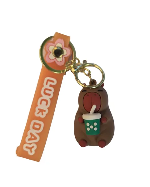 Brown hippo PVC keyring holding a green bubble tea cup, on an orange printed strap reading LUCK DAY